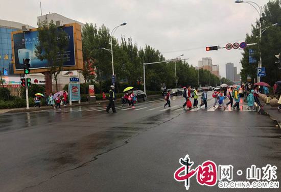 濱州交警開發(fā)區(qū)大隊(duì)：雨天“護(hù)學(xué)崗”上的澆警為學(xué)生撐起“安全傘”